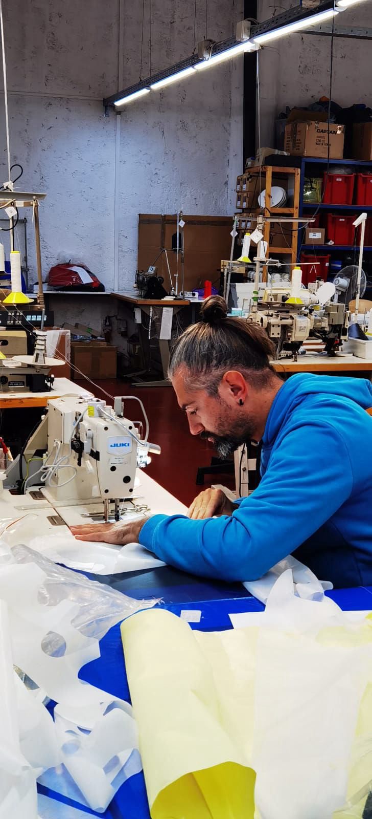 Repairing paraglider with sewing machine.